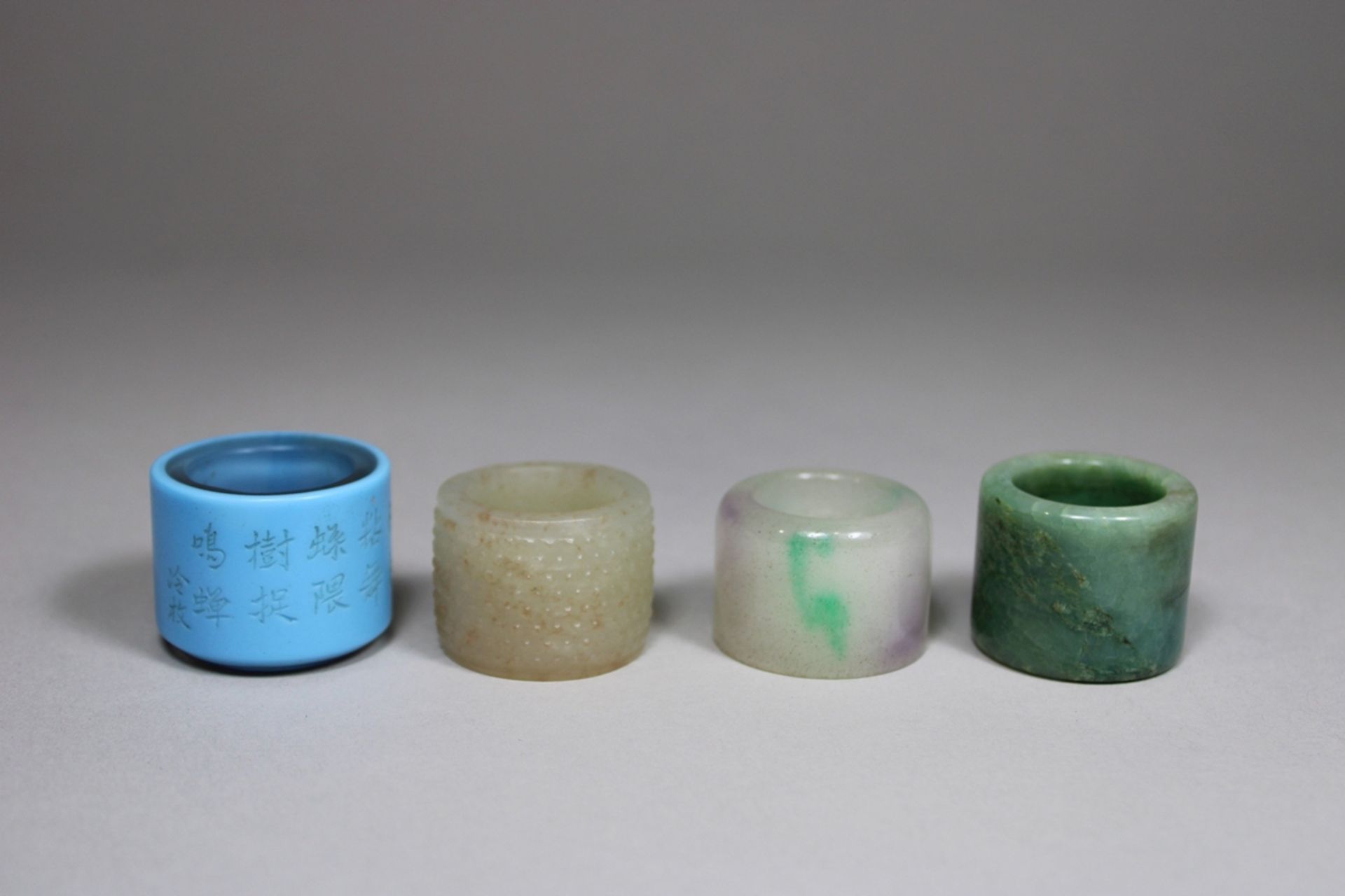 Vier Daumen-Ringe, China, 2 aus Jade, 1 weißer Jade, 1 aus Doppelschicht-Glas mit Gedicht, wohl Qin