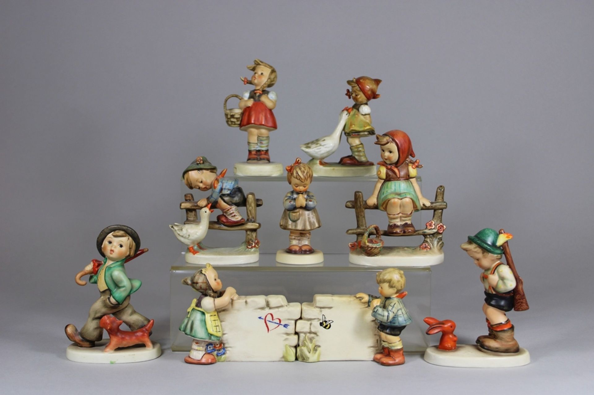 Neun Porzellanfiguren, Kinder, Goebel, Hummelfiguren, am Sockel signiert, H.: von 10 bis 12,9 cm. G