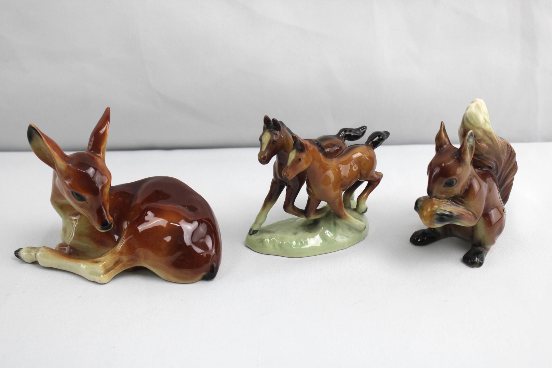 Drei Porzellan Tierfiguren, Reh, Pferde und Eichhörnchen