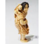 Netsuke, kleine Schnitzfigurengruppe, Japan. "Frau mit Posaune und Baby auf dem Rücken".