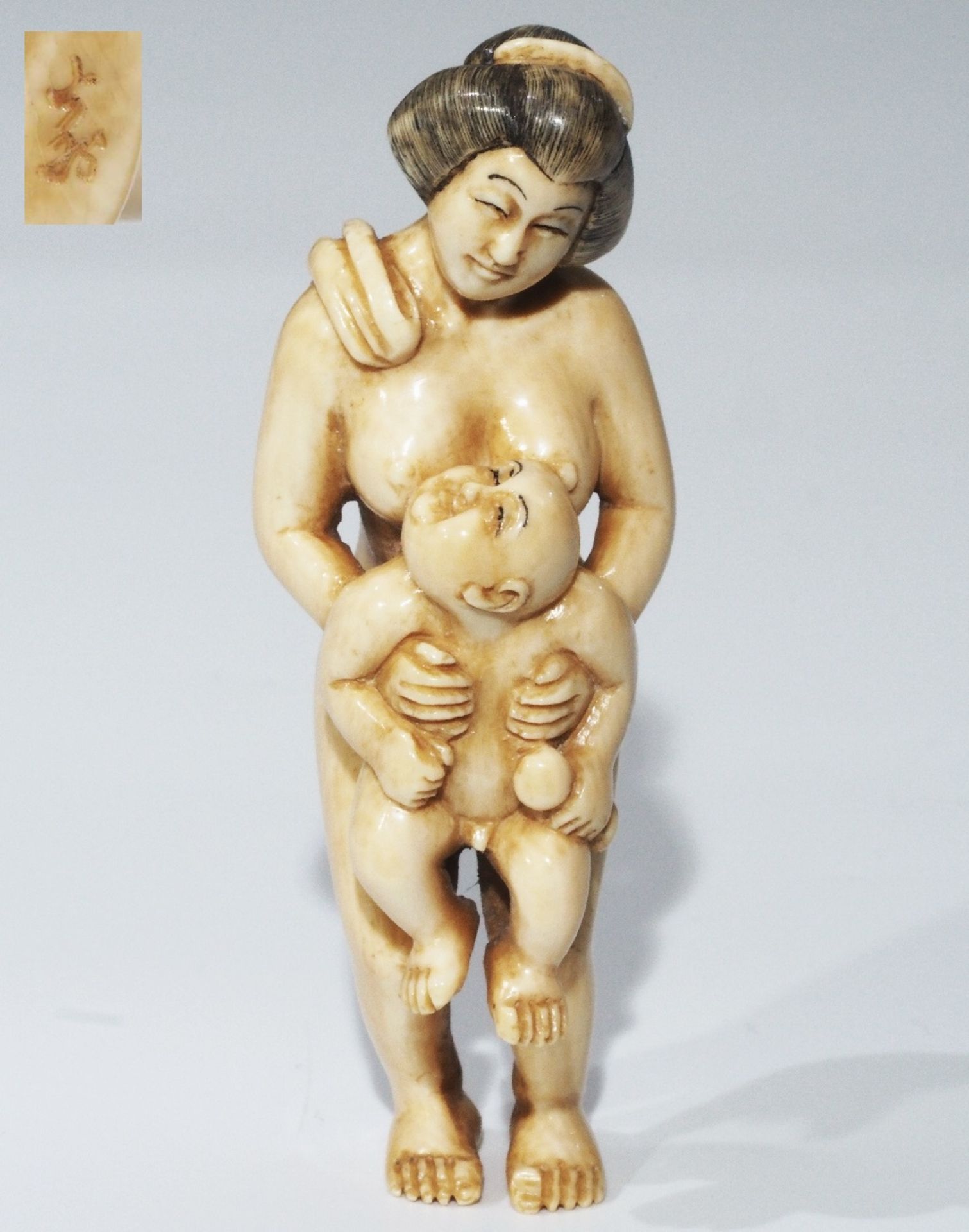 Netsuke, kleine Schnitzfigur, Japan. Erotika, Frau mit Kleinkind.