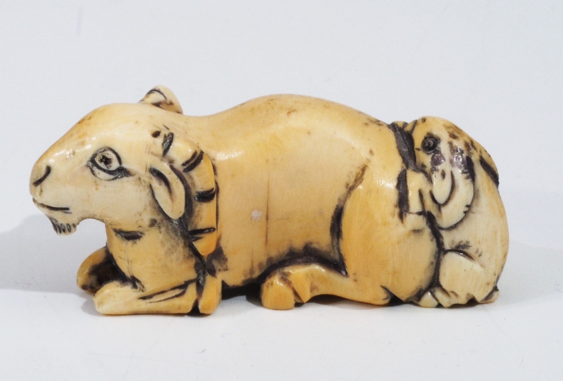 Netsuke, Kleine Schnitzfigur, Fabelwesen, "Liegende Ziege mit einem Jungen".