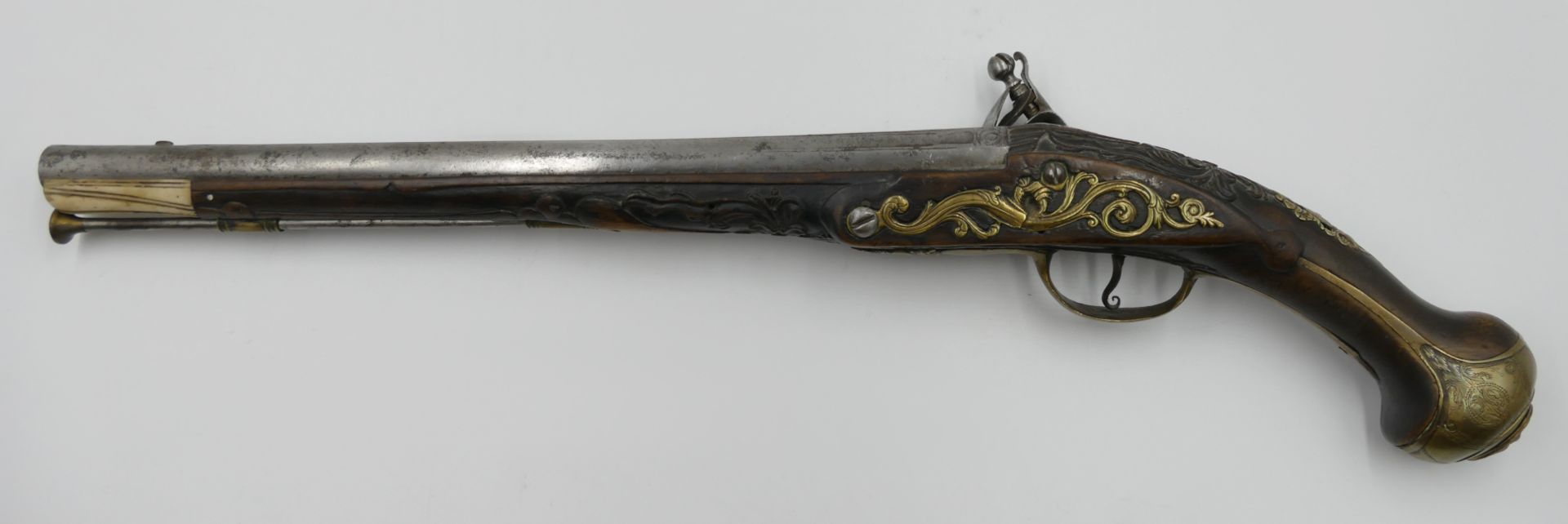 1 Steinschlosspistole wohl 18. Jh. beschnitzter Holzschaft mit Beinende und runder z.T. gravierter L