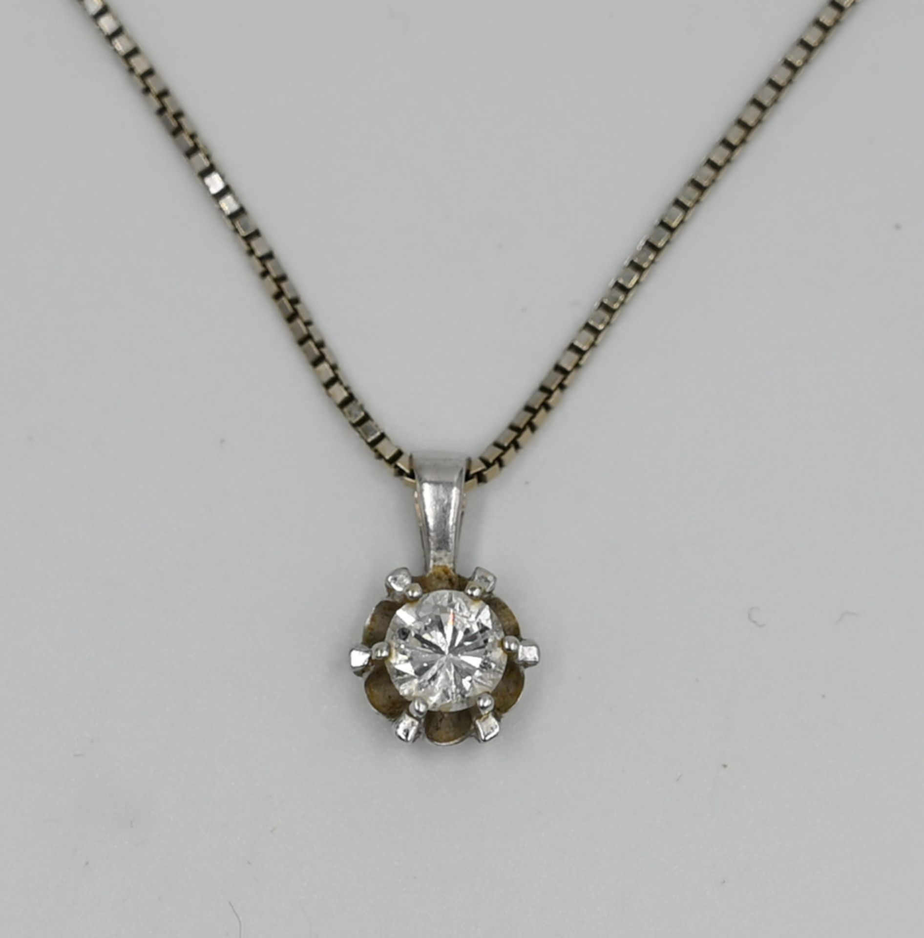 1 Kette, 1 Anhänger, je WG 14ct., mit Solitärbrill. wohl ca. 0,6ct., besch. (am Rand), je Tsp.