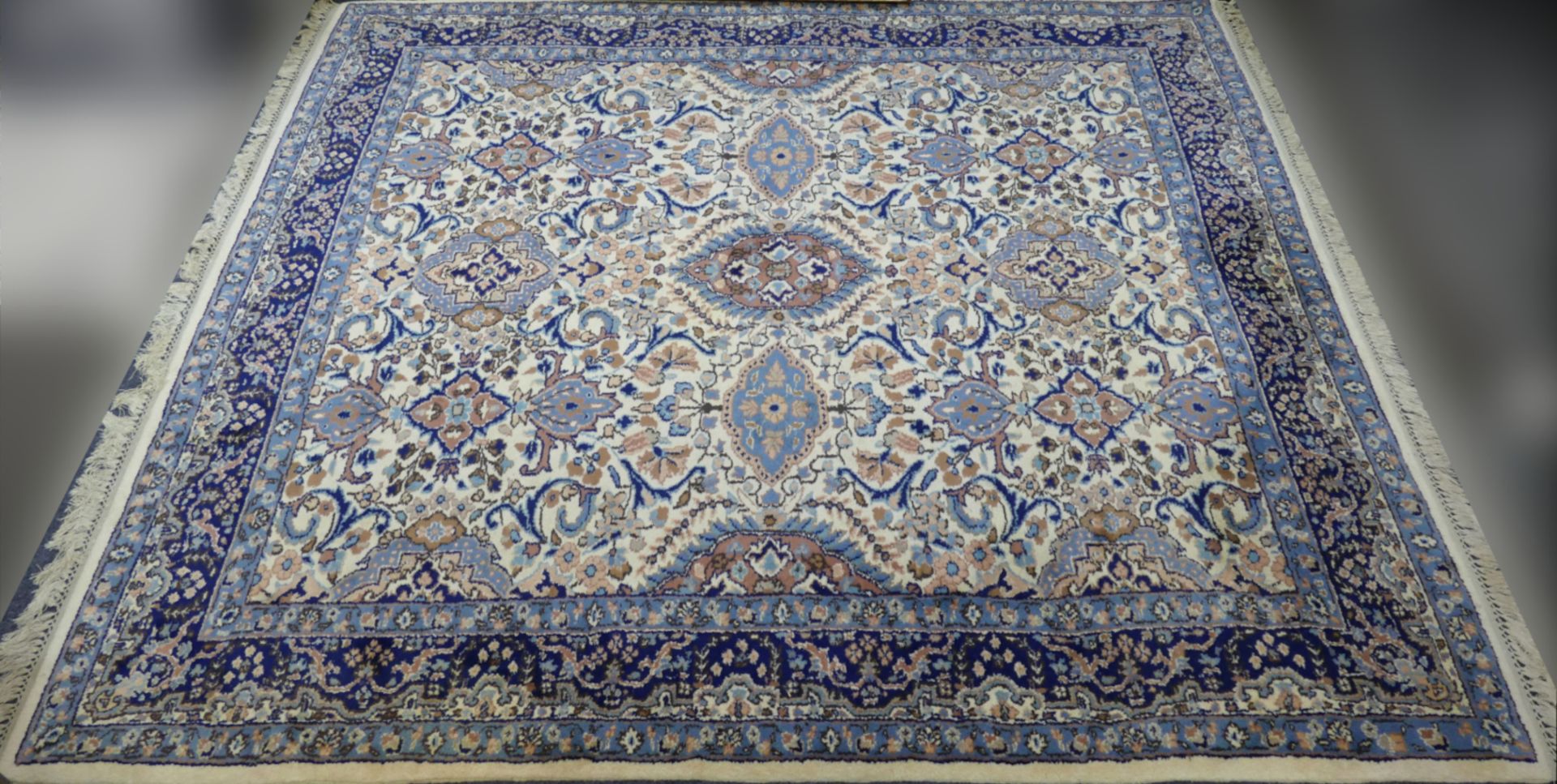 1 Orientteppich beigegrundig mit großformatigem floralen Dekor und dunkelblauer Randbordüre, ca. 244