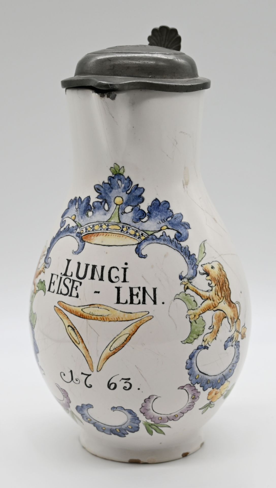 1 Fayencekanne wohl 18. Jh. unters. gemarkt "M", frontseitig auf Wandung bez. "Lungi Eise-Len 1763",