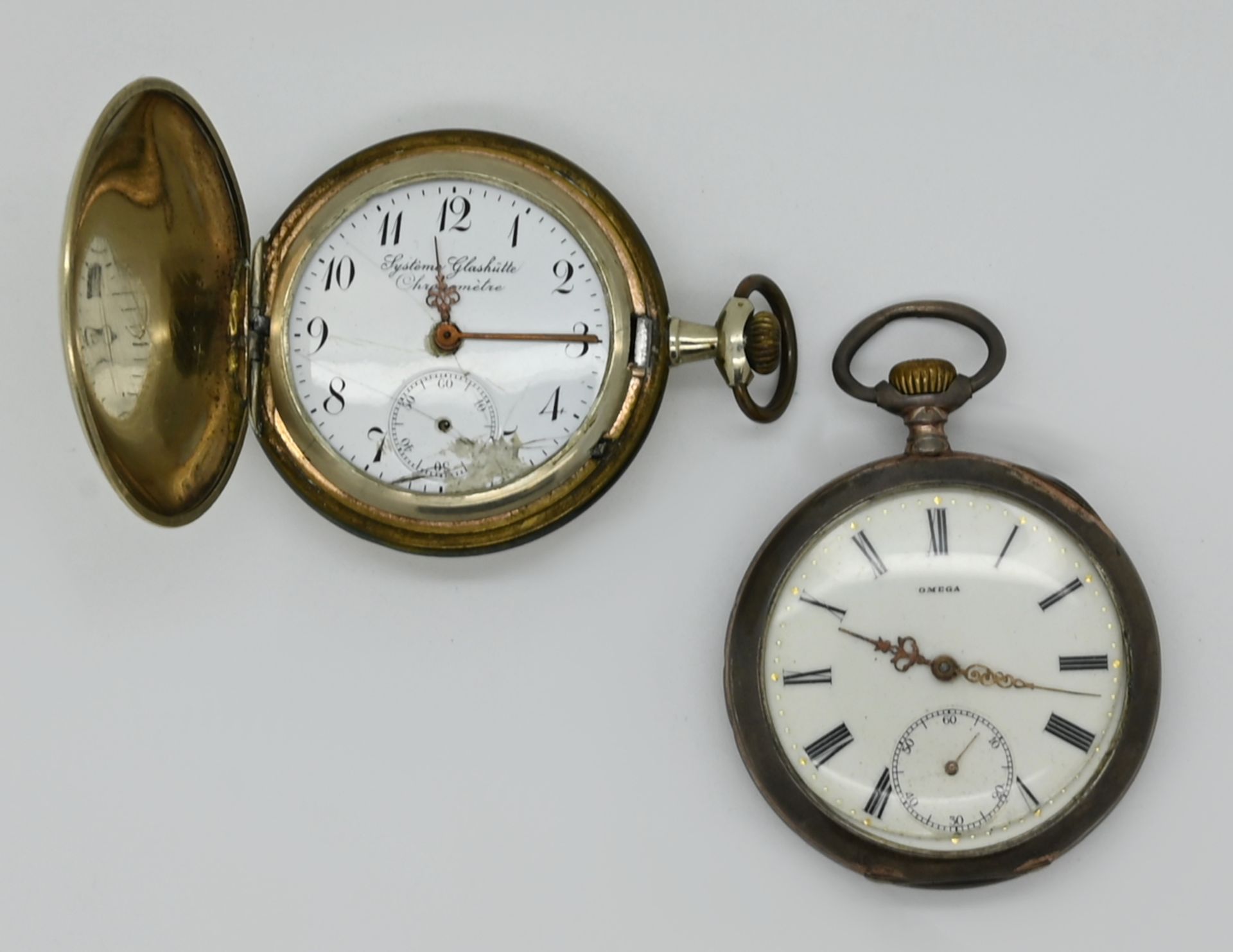 1 Taschenuhr OMEGA, z.T. Silber (1 Rückdeckel fehlt), Glas lose sowie 1 Herrentaschenuhr Metall, SYS