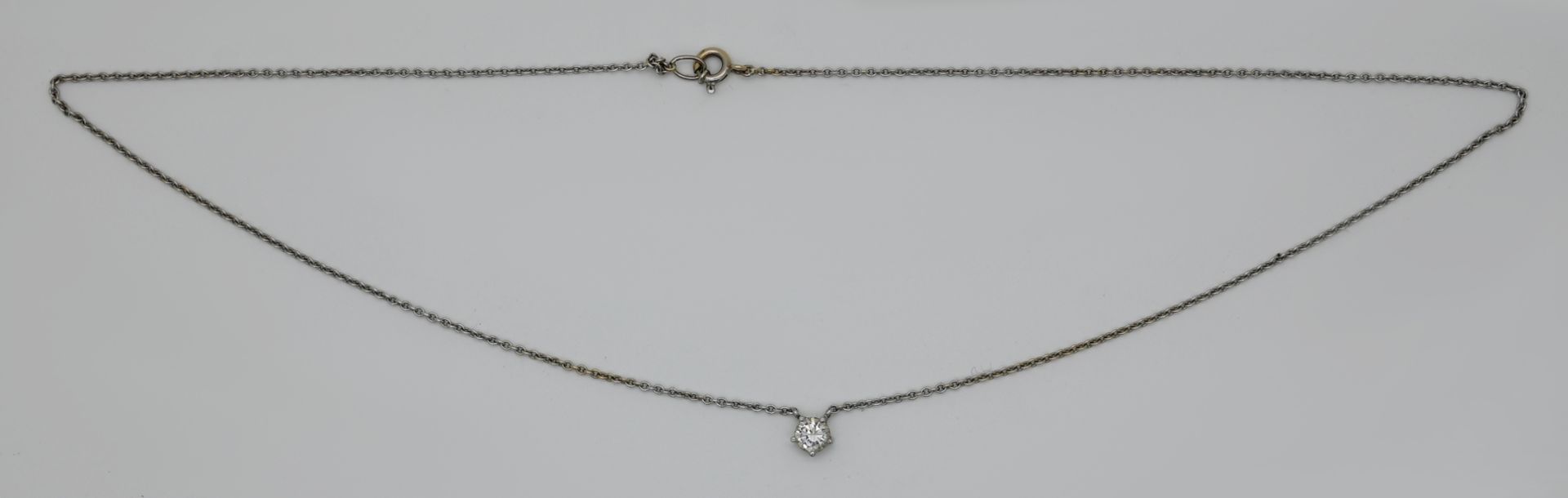 1 Collier wohl ungestempelt, wohl WG, mit Solitärbrillant ca. 0,3ct. (D. ca. 0,45cm), Tsp. - Image 2 of 2