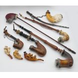 9 Pfeiffen Anfang wohl 20. Jh. z.T. Holz/Meerschaum beschnitzt "Frauenhaupt", "Löwenrudel" u.a., bis