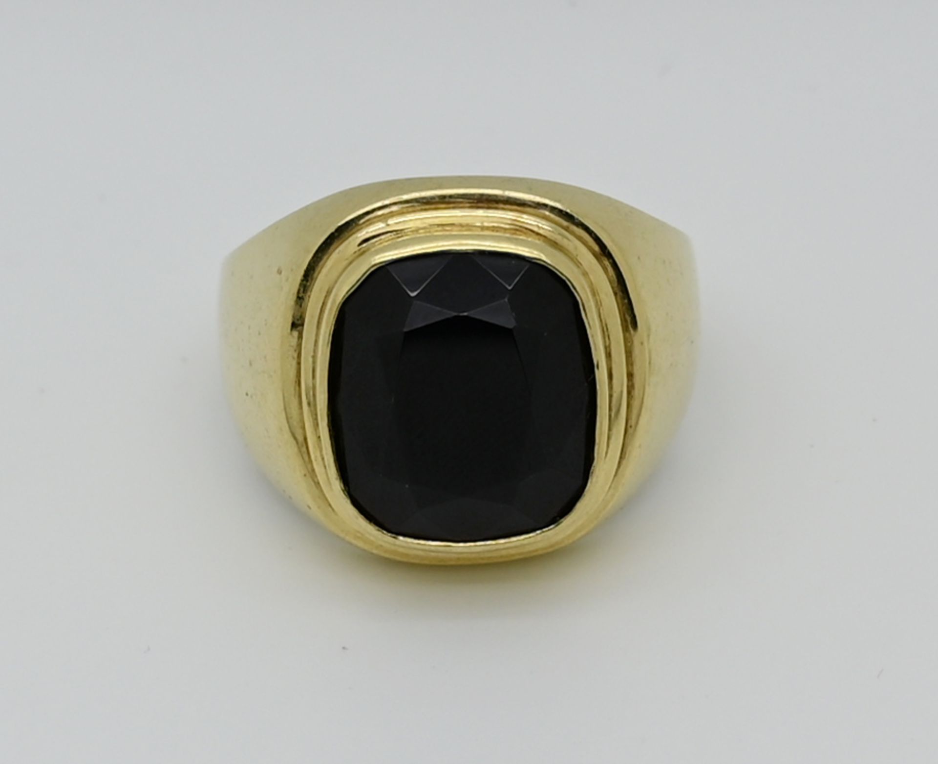 1 Herrenring undeutlich gestempelt, wohl GG 8ct. oder 14ct., mit dunklem Stein, Ringgr. ca. 64, Tsp.