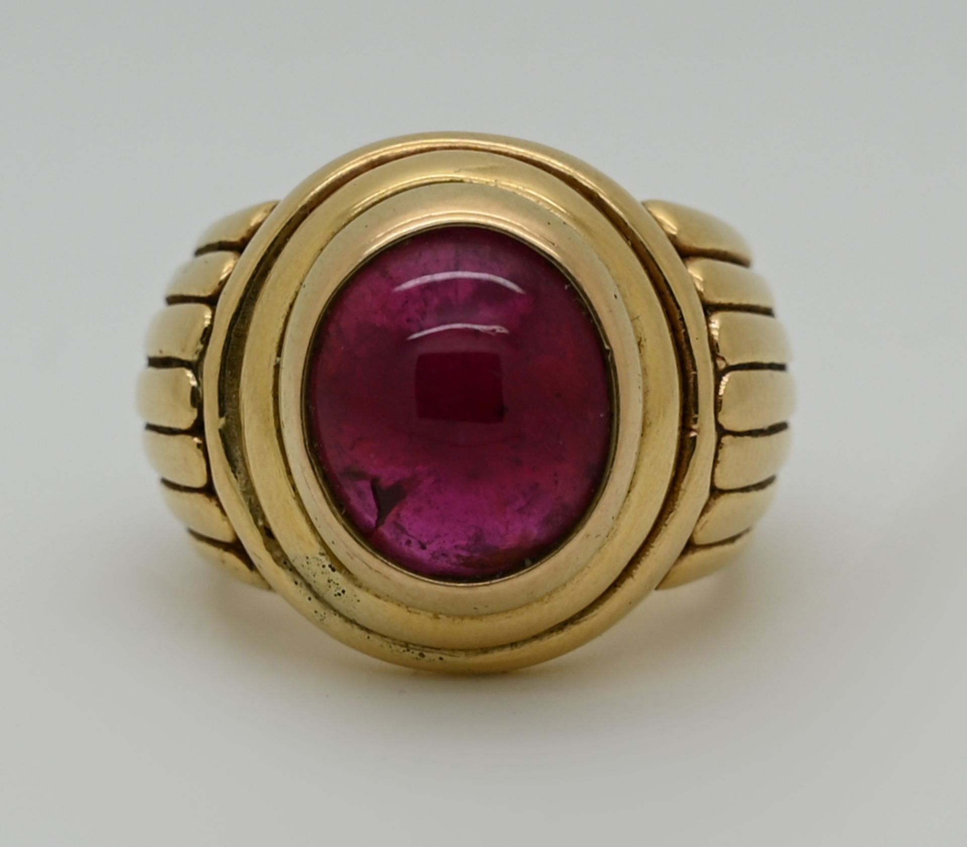 1 Ring GG 18ct. mit himbeerfarbenem Edelstein im Cabochonschliff, L ca. 1,2 cm, B ca. 1 cm, J. SMITH