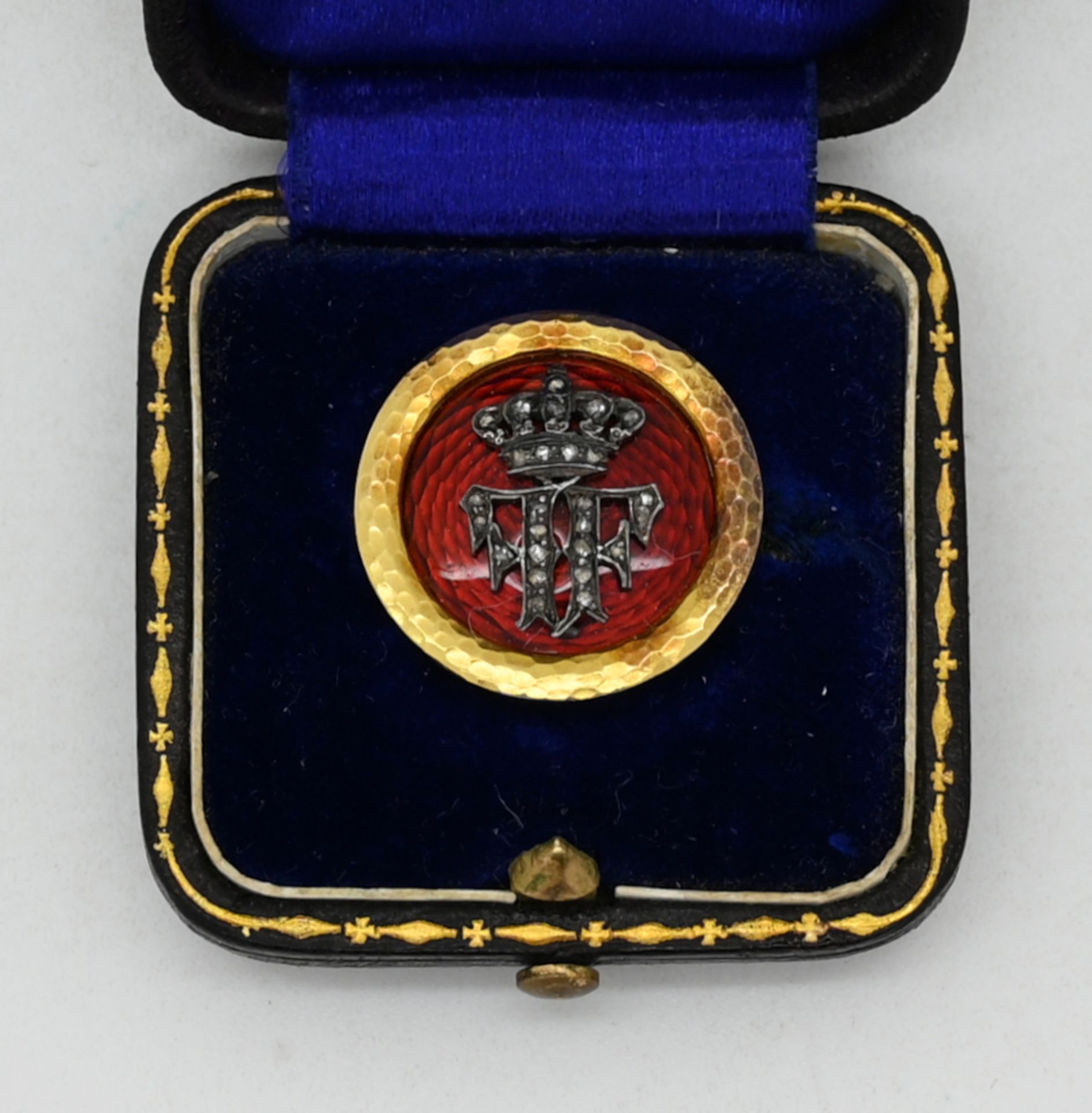 1 kleine Brosche, ungestempelt wohl GG, mit Monogramm "FF" und Krone, rotes Emaille, Diamanten, D 2c