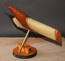 A mid-20th century brass-accented beech table lamp, as a rocket-powered aircraft, parcel-ebonised