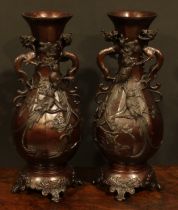 A pair of Japanese brown patinated bronze panelled baluster vases, cast with song birds and