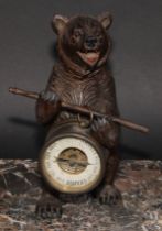 An early 20th century Black Forest carving, of a bear, holding an aneroid barometer, 21cm high