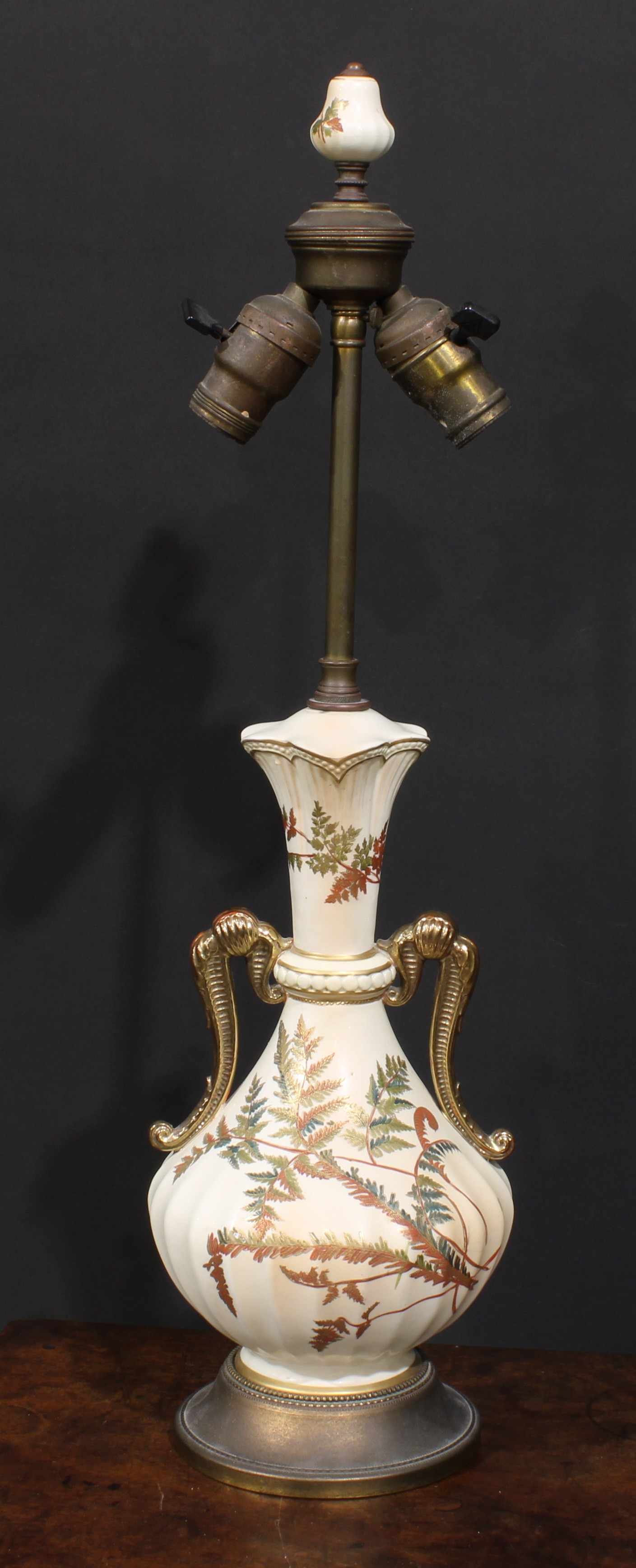 A Royal Worcester blush ivory fluted ovoid table lamp, decorated and picked out in gilt with fern,