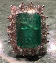 A certified emerald and diamond cluster ring, central Zambian elongated octagonal step cut
