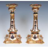 A pair of Royal Crown Derby Imari palette 1128 pattern Castleton candlesticks, shaped square bases
