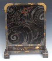 A Japanese lacquer table screen, decorated with the sun rising behand crashing waves, gilt brass