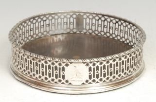 A George III silver circular wine coaster, gadrooned rim, pierced border, 14cm diam, London 1774