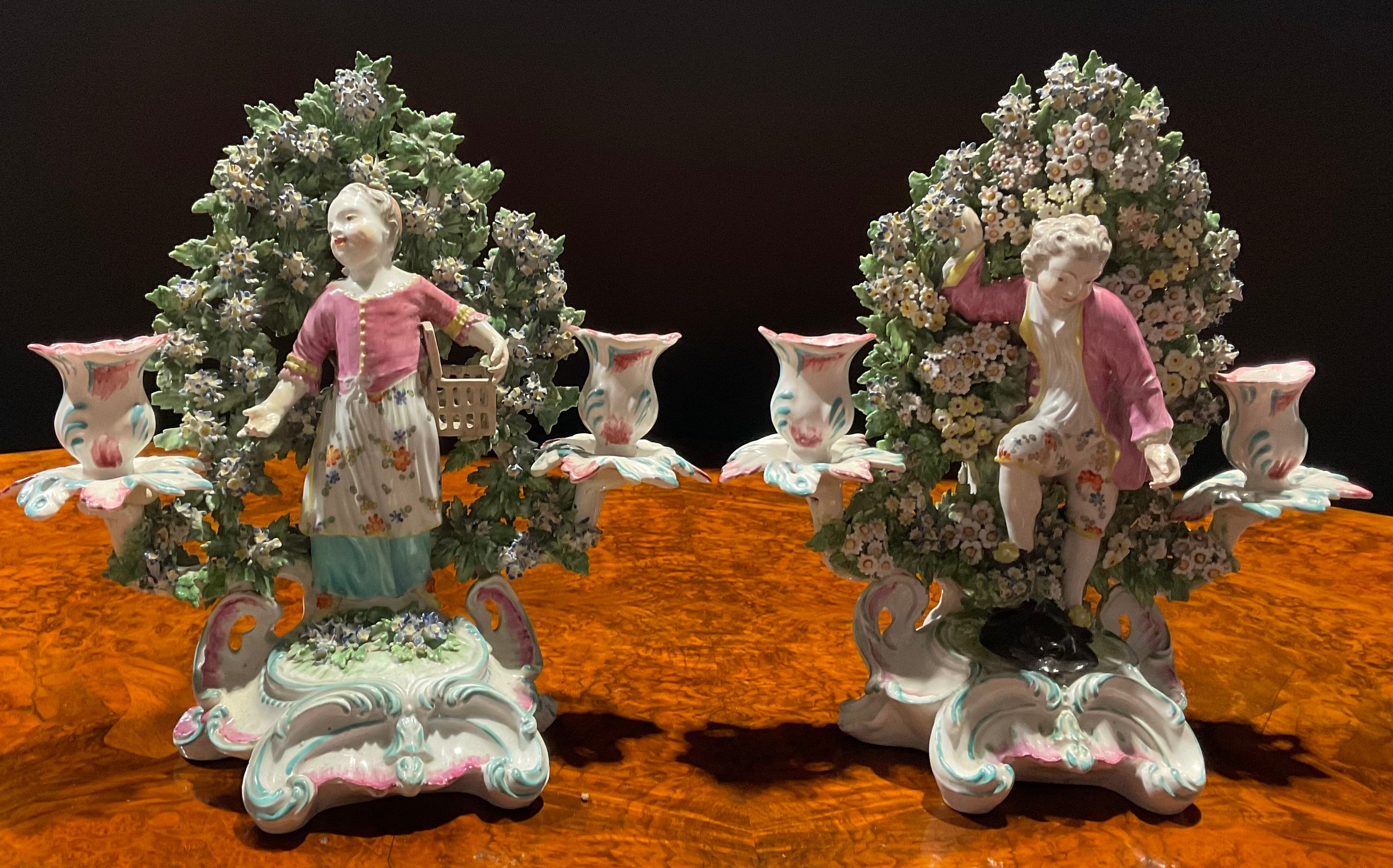 A pair of Derby figural candlesticks, before floral bocage, of children Liberty and Matrimony, the