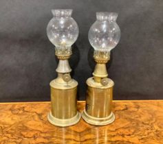 A pair of early 20th century French brass oil lamps, the Lampe Pigeon, glass storm shades, 23.5cm