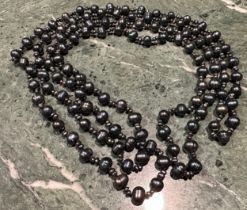 A long single strand of Tahitian circle pearls, each divided by two small seed pearls, 88cm drop