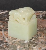 A Chinese celadon jade seal, carved with an archaic ox, 3.5cm high