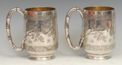 A pair of Chinese silver pint mugs, each engraved with with birds on branches, and insects, within