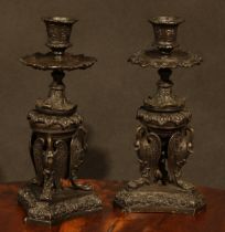 A pair of 19th century dark patinated bronze candlesticks, in the Grand Tour manner, cast with