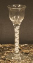 A George III opaque twist drinking glass, bell shaped bowl, triple-helix stem, domed circular