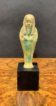 Antiquities - an Egyptian shabti, traces of turquoise glaze, 15cm high, collector's display plinth