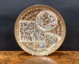 A Japanese satsuma circular dish, profusely decorated with panels of figures on a banded floral