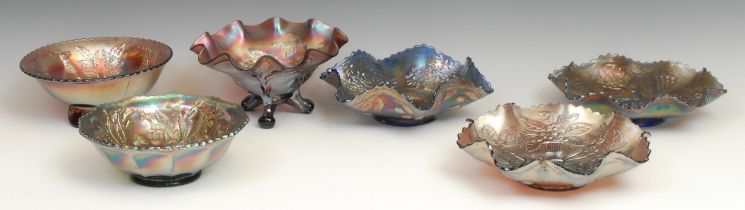 A carnival amethyst glass shaped circular bowl, moulded in low relief with a peacock and leafy