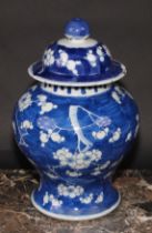 A Chinese baluster ginger jar and cover, painted in tones of underglaze blue with blossoming