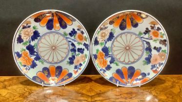 A pair of Chinese Imari circular plates, decorated with mons and flowers, picked out in gilt, 21.5cm