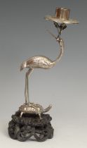 A Chinese silver candlestick, as a crane standing on a turtle, pierced and carved hardwood base,
