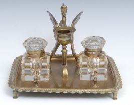 A 19th century brass inkstand, the handle cast as a wyvern, the square cut glass wells centred by