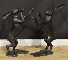 A pair of contemporary dark patinated bronzed metal models, boxing hares, the largest 85cm high, the