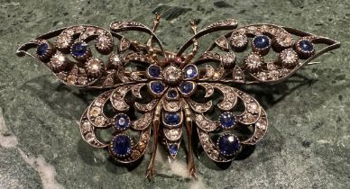 A late Victorian/Edwardian diamond, sapphire and ruby encrusted butterfly brooch, the unmarked