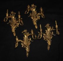 A set of four Louis XV Revival gilt metal wall lights, cast in the rococo taste, 35cm high, 30cm