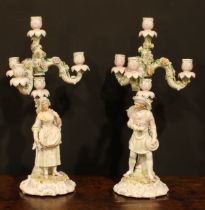 A pair of Continental porcelain four-light table candelabra, figural bases, the branches encrusted