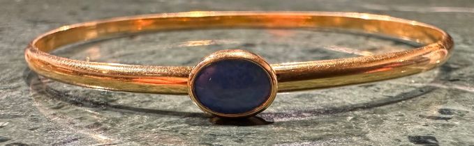 A Opal set indistinctly marked gold bangle, rounded body set with a single deep blue green oval