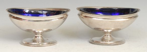 A pair of Chinese silver oval pedestal salts, blue glass liners, 11cm wide, character marks, c.1890,