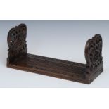 An Anglo-Indian hardwood bookslide, pierced and carved with flowers and scrolling foliage, 34cm