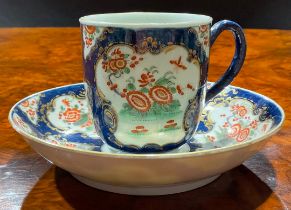 A Worcester coffee cup and saucer, decorated with alternating fan and vase shaped reserves, each