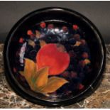 A Moorcroft Pomegranate pattern circular bowl, tube lined with large fruit and berries, on a mottled