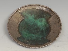 A French Modernist silver and enamel circular dish, decorated in tones of verdigris on a planished