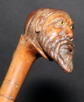 A 19th century walking stick or cane, the pommel carved as the head of a bearded man, wearing a fez,