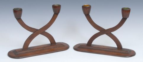 A pair of Secessionist mahogany two-light table candelabra, curved X-shaped branches, stepped